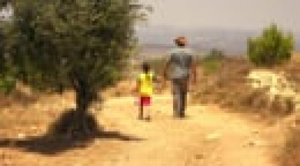 adult and child walking on a dirt path